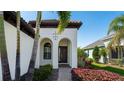 Front entrance with arched entryway, landscaping and walkway at 413 Wildlife Gln, Bradenton, FL 34209