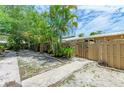 Side yard view showing a pathway, wooden fence, and tropical plants at 500 N Jefferson Ave # C3, Sarasota, FL 34237