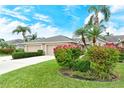 Two-unit building with tan exterior, attached garages, and tropical landscaping at 5150 Mahogany Run Ave, Sarasota, FL 34241