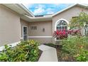 House exterior showing walkway to front door, surrounded by lush landscaping at 5150 Mahogany Run Ave, Sarasota, FL 34241