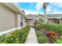 Welcoming walkway to front door, surrounded by colorful flowers and greenery at 5150 Mahogany Run Ave, Sarasota, FL 34241