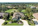 Aerial view of a single Gathering home with well-manicured lawn, mature trees, and golf course views at 5304 96Th E St, Bradenton, FL 34211