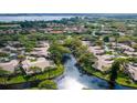 Aerial view of a residential area with mature trees and a winding waterway in the landscape at 5653 Pipers Waite # 26, Sarasota, FL 34235