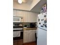 Galley kitchen with white cabinets and stainless steel appliances at 6067 Arlene Way, Bradenton, FL 34207