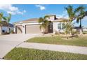 Tan single-story house with a three car garage and lush landscaping at 12822 Rainwashed Loop, Parrish, FL 34219