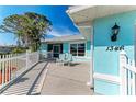 Charming front porch features seating, crisp white picket fence, and vibrant blue exterior paint at 1346 Queen Rd, Venice, FL 34293