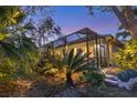 View of screened lanai and tropical landscaping at 1359 Tearose Pl, Sarasota, FL 34239