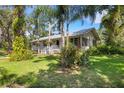 Single story home with a white exterior and green lawn at 14018 Pine Woods E Ln, Sarasota, FL 34240