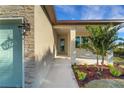 Inviting front porch with light colored stone and a lush tropical landscaping at 144 Spring Dr, Rotonda West, FL 33947