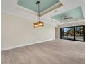 Spacious living area with light walls, wood-look floors, and a tray ceiling at 144 Spring Dr, Rotonda West, FL 33947