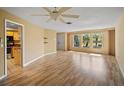 Spacious living room featuring light wood laminate flooring and a ceiling fan at 157 Da Vinci Dr, Nokomis, FL 34275