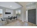 Modern dining area featuring sleek black chairs, light wood floors, and a stylish entryway at 1671 Mellon Way, Sarasota, FL 34232