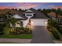 Gorgeous home exterior featuring a manicured lawn, brick driveway and three-car garage at 16730 Collingtree Xing, Lakewood Ranch, FL 34202