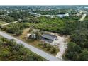 Aerial view of a property showcasing its setting on a large lot with lush greenery, providing a serene and private atmosphere at 17555 Lake Worth Blvd, Port Charlotte, FL 33948