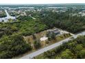 This aerial shot highlights the property's peaceful location on a large, verdant lot, set back from the road for added privacy at 17555 Lake Worth Blvd, Port Charlotte, FL 33948