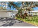 Inviting home featuring a carport, vibrant landscaping, and a freshly paved driveway at 1873 University Pl # 135, Sarasota, FL 34235