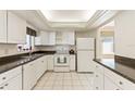 The brightly lit kitchen showcases white appliances, cabinetry and tile floors, with a dark countertop at 1873 University Pl # 135, Sarasota, FL 34235