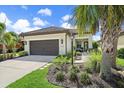 One-story house with a brown garage door and lush landscaping at 220 Alfero Way, Nokomis, FL 34275