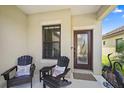 Front porch with two rocking chairs and decorative bird statues at 220 Alfero Way, Nokomis, FL 34275