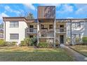 Condo exterior featuring well-maintained landscaping and an open-air stairwell to the second-story units at 2400 Winding Creek Blvd # 25-102, Clearwater, FL 33761