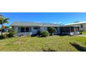 Rear view of the house, showing a screened porch and additional landscaping at 2701 Larkspur Dr, Punta Gorda, FL 33950