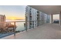 Expansive balcony with glass railings offers panoramic ocean views at sunset from this modern waterfront condo at 301 Quay Commons # 1411, Sarasota, FL 34236