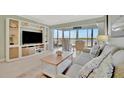 Living room with water views, comfy seating, and built-in entertainment center at 4430 Exeter Dr # 104, Longboat Key, FL 34228