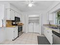 Bright kitchen with white cabinets, stainless steel appliances, and convenient in-unit laundry at 4565 Mohican Trl # 129, Sarasota, FL 34233