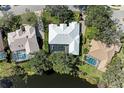 An aerial view of a home with a screened-in pool and lush backyard adjacent to a pond at 4749 Antler Trl, Sarasota, FL 34238