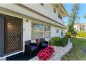 Condo entrance with patio furniture and colorful flowers at 527 Sutton Pl # T-12, Longboat Key, FL 34228