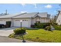 Front view of a lovely villa with a white garage door and lush landscaping at 5388 Pamela Wood Way # 8, Sarasota, FL 34233