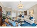 Elegant living room featuring a beautiful chandelier, stylish furniture, and bright natural light at 5507 Country Lakes Trl, Sarasota, FL 34243