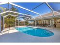 Inviting screened-in pool area with ample seating, a dining set, and lush tropical landscaping at 5507 Country Lakes Trl, Sarasota, FL 34243