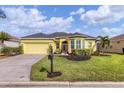 Single-story house with yellow exterior, green trim, and a two-car garage at 5703 52Nd W Ave, Bradenton, FL 34210