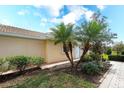 Landscaped front yard with palm trees and brick walkway leading to the front door at 6063 Benevento Dr, Sarasota, FL 34238