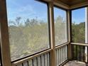 Screened porch with view of the surrounding landscape at 611 Cedars Ct, Longboat Key, FL 34228