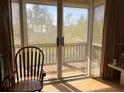 Sliding glass doors open to a balcony overlooking lush green trees at 611 Cedars Ct, Longboat Key, FL 34228