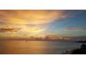 Stunning sunset over the ocean with beach and distant boat at 613 Chevy Chase Dr, Sarasota, FL 34243