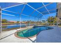 Kidney-shaped pool with a screened enclosure overlooking a lake at 6978 Superior Street Cir, Sarasota, FL 34243