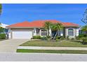 Single-story home with tile roof, two-car garage, and manicured landscaping at 12823 Penguin Dr, Bradenton, FL 34212