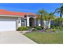 Front view of home showcasing tile roof, landscaping, and two-car garage at 12823 Penguin Dr, Bradenton, FL 34212