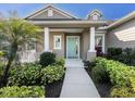 Inviting front entrance with a charming aqua blue door and lush landscaping at 13922 Old Creek Ct, Parrish, FL 34219