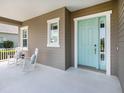 Cozy front porch with rocking chairs and a welcoming aqua front door at 13922 Old Creek Ct, Parrish, FL 34219