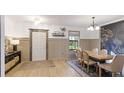 Dining room with a wooden table, six chairs, a decorative rug, and wainscoting at 14318 Fissore Blvd, Wimauma, FL 33598