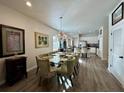 A spacious dining room features a chandelier, a glass table with seating, and an open view to the kitchen at 1790 White Orchid Ct, Sarasota, FL 34235