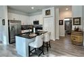 Bright kitchen featuring white cabinets, stainless steel appliances, and a black countertop island with barstool seating at 1790 White Orchid Ct, Sarasota, FL 34235