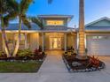 Inviting entryway to a charming coastal home with lush landscaping at 221 Lychee Rd, Nokomis, FL 34275