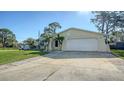 Single-story home with a well-kept lawn and wide driveway leading to an attached two-car garage at 2407 Amanda Dr, Sarasota, FL 34232