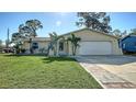 Charming single-story home with lush front lawn, complemented by palm trees and a wide driveway at 2407 Amanda Dr, Sarasota, FL 34232