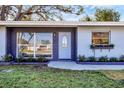 Charming home featuring a stylish front door, window flower boxes, and freshly landscaped yard at 3446 Monica Pkwy, Sarasota, FL 34235